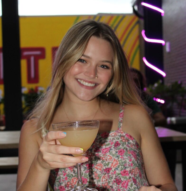 College student smiling with a drink at a brand ambassador event for a student living apartment