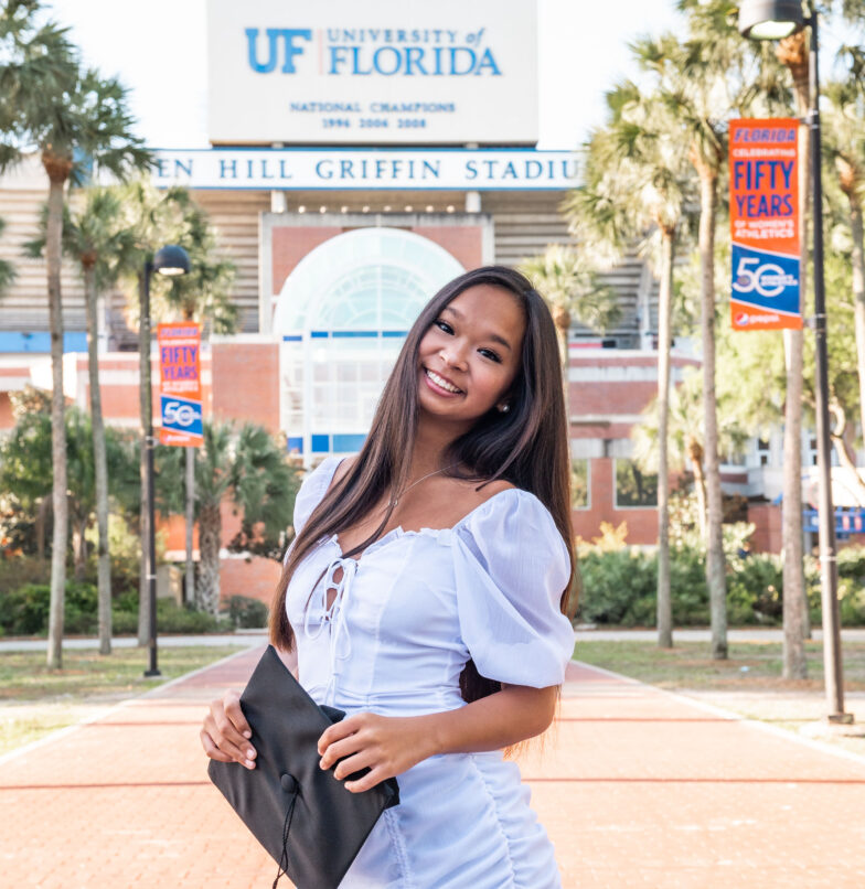 University of Florida graduate smiling in front of the Swamp