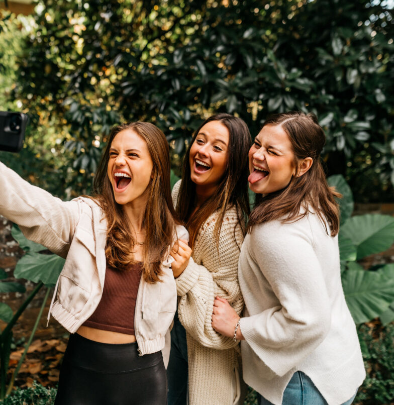 Three girl UGA students smiling in front of a camera for a selfie of themselves in Athens, Georgia.