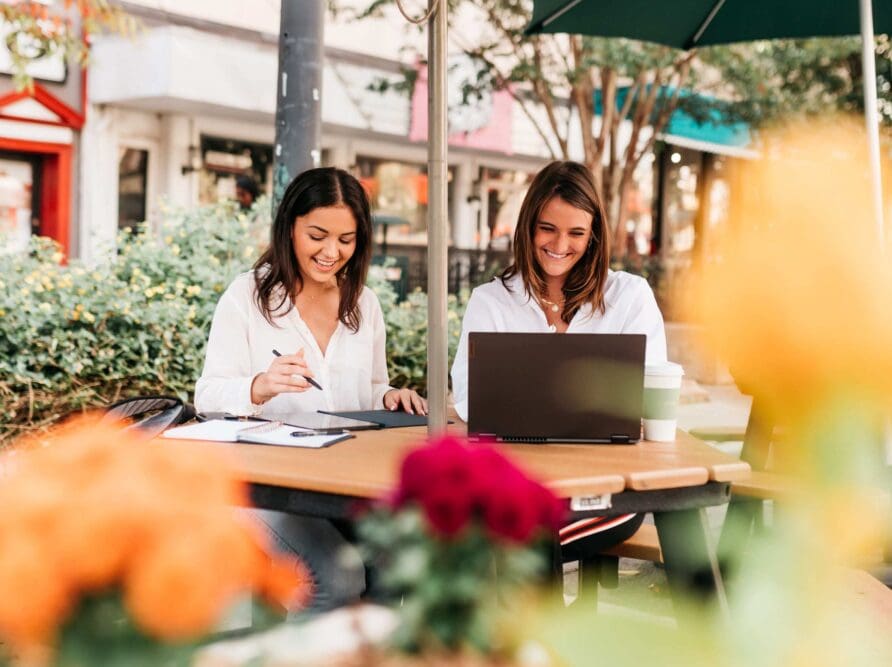 Two girls studying together and smiling