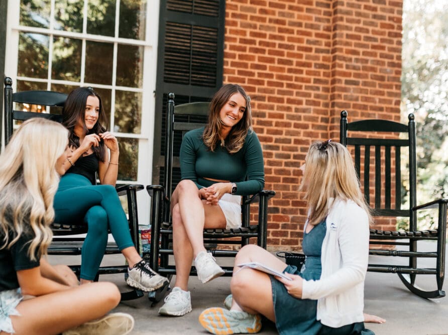 Friends sitting on sorority house steps on Milledge Avenue in Athens, GA.