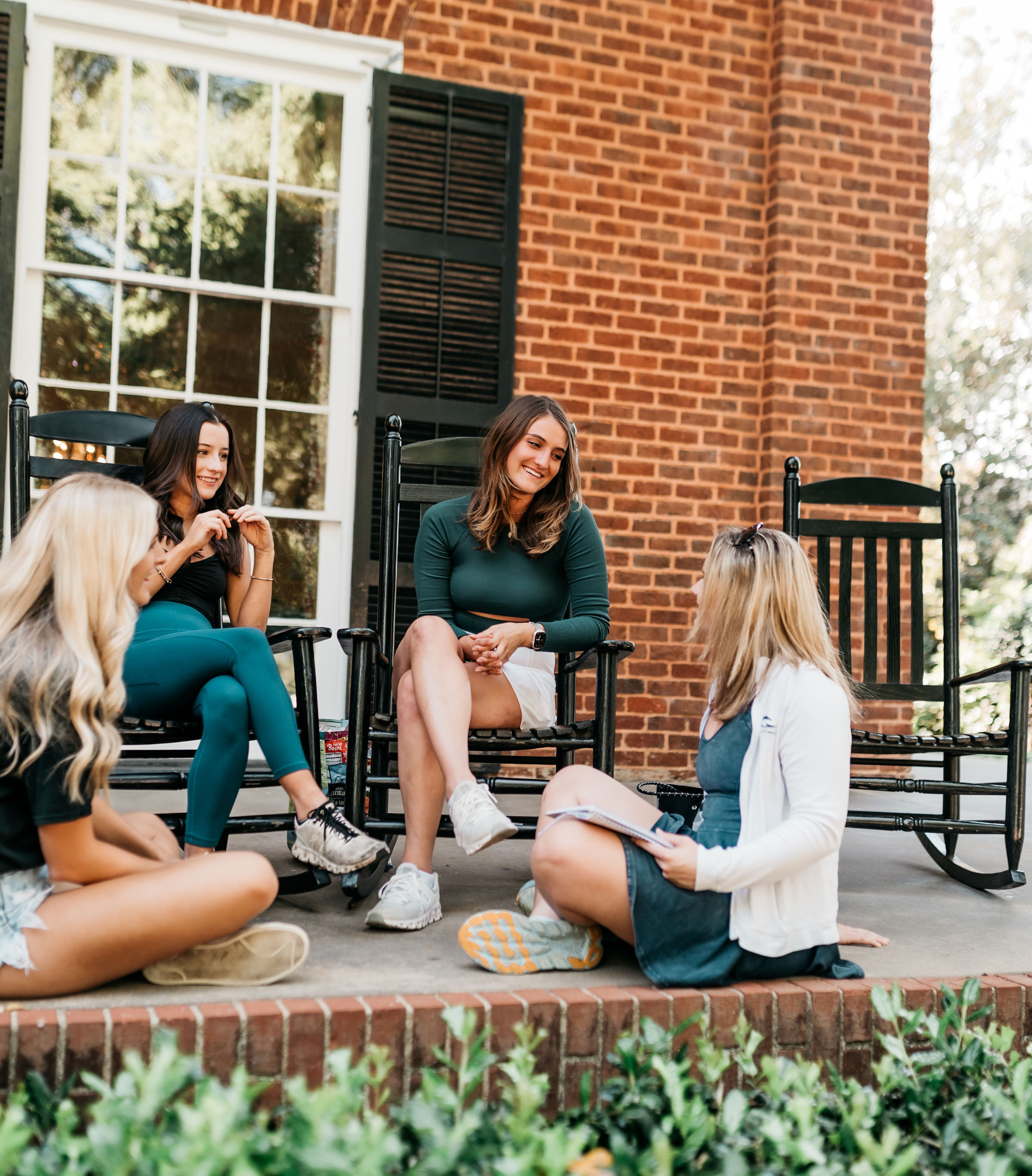 Friends sitting on sorority house steps on Milledge Avenue in Athens, GA.