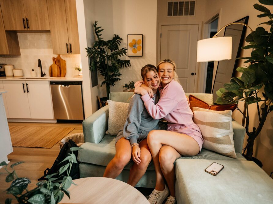 Two girls hugging on a couch